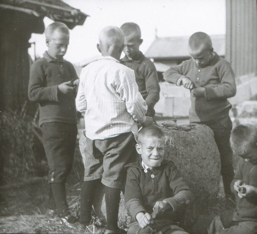 svart-hvitt bilde av flere unge gutter i lek