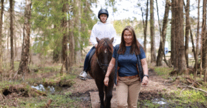 Bildet viser Anette Elvestad Storeide, leder en hest med et barn som rir