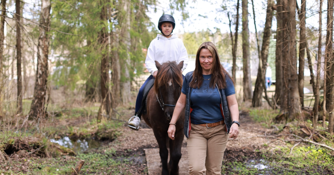 Bildet viser Anette Elvestad Storeide, leder en hest med et barn som rir